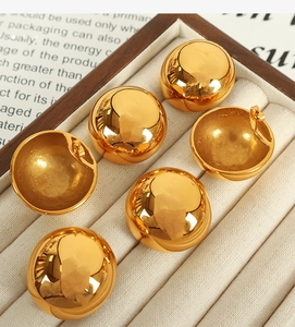 Detail of high-polish gold dome stud earrings arranged in a premium velvet jewelry box