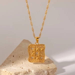 Detail of 18K gold square pendant with moon motif and zircon on water wave chain