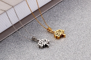 Detailed view of Tree of Life pendants in polished silver and gold stainless steel