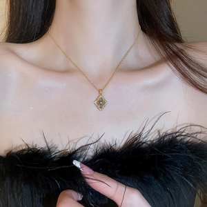 Detail of a vintage gold-plated clover pendant necklace with sparkling rhinestones