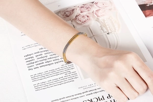 Close-up of two-tone gold and silver chain bracelet worn on a model's wrist