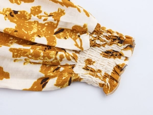 Détail des poignets élastiques smockés et bords volantés sur manches de robe ethnique