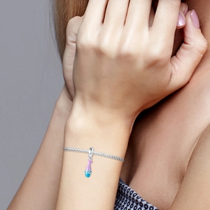 Close-up of a pearlescent gradient mermaid tail charm on a 925 silver woven bracelet