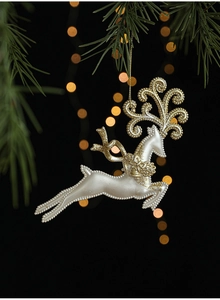 Ornement de Noël renne blanc et doré scintillant suspendu à une branche de sapin