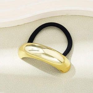 Detailed close-up of a high-quality black elastic hair tie with a curved gold metal finish