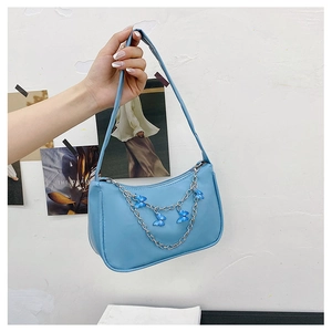 Detail of light blue PU leather underarm bag with silver chain and blue butterfly charms