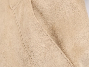 Vue macro du tissu en daim beige sable et des coutures précises sur la poche du blouson