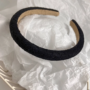 Detailed view of black lace fabric headband with intricate hollowed flower patterns