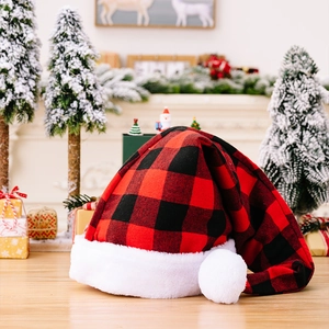 Classic red and black buffalo plaid Christmas hat with white plush trim on wood floor