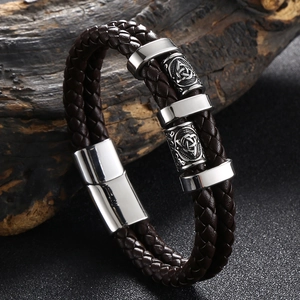 Détail d'un bracelet en cuir tressé marron avec perle en acier gravée d'un nœud celtique
