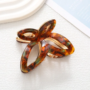 Detailed view of large tortoiseshell acetate claw clip with amber butterfly wing patterns