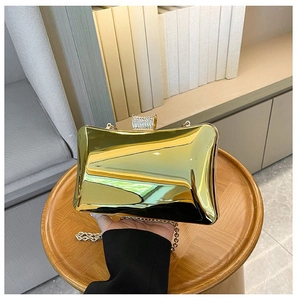 Detailaufnahme der goldenen Acryl-Box-Clutch mit Strassverschluss und feiner Metallkette