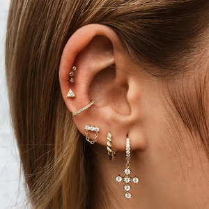 Detail view of gold S925 sterling silver star and geometric stud earrings for ear stacking
