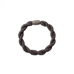 Close-up of a dark grey twisted elastic hair tie with a smooth matching bead detail