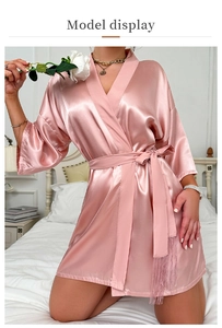 Detail of pink silk satin robe featuring elegant waist tie with decorative fringe tassels