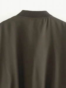 Vue détaillée de la veste vert foncé montrant le col côtelé et la texture du tissu de luxe