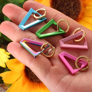 Detailed view of colorful neon enamel V-shaped triangle hoop earrings held in hand