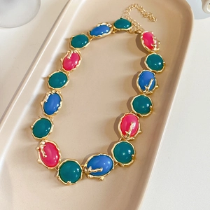 Détail de collier vintage avec incrustations en résine et bords en métal doré irrégulier