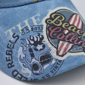 Macro shot of light blue washed denim cap featuring vintage surf prints and detailed stitching