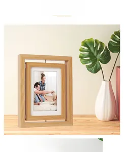 Close-up of a rotating double-sided wooden photo frame on a minimalist desk surface