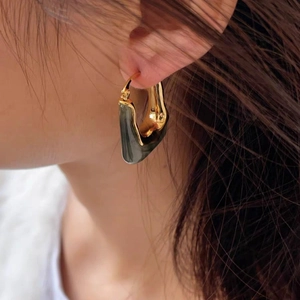Vintage U-shaped amber style earrings with 18K gold plating on model side view