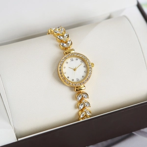 Detail of gold luxury watch with leaf-shaped crystal bracelet in a premium gift box