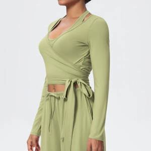 Detail view of v-neck long sleeve yoga top with side tie bow and olive green wide leg pants