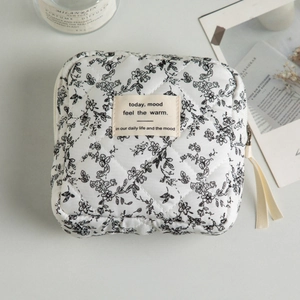 Close-up of quilted floral cosmetic bag with cotton fabric and metallic zipper detail