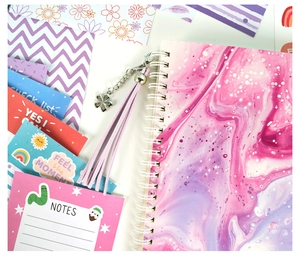 Flat lay of purple marble journal set with tassel charm and creative stationery cards
