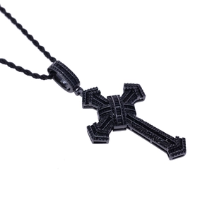 Detailed close-up of a black cross pendant with inlaid black gemstones on a rope chain