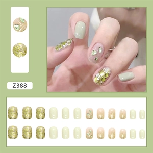 Detail view of model Z388 press-on nails with mint green and gold glitter design