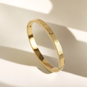 Detailed macro view of gold titanium steel bangle with musical notes and LOVE engraving