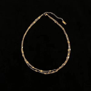 Detailed view of triple-layered 18K gold-plated steel necklace with lobster clasp
