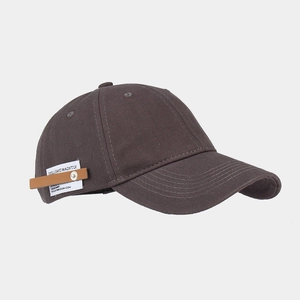 Detail view of cotton baseball cap featuring side white woven label and leather strap