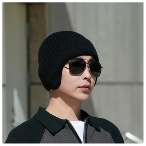Detail of a black knit earflap hat for men, featuring a thick vertical ribbed texture