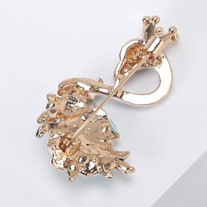 Golden swan brooch pin back view with detailed metal base and crown shape on white background