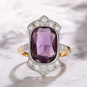 Macro shot of vintage French style gold ring with cushion-cut purple gemstone detail
