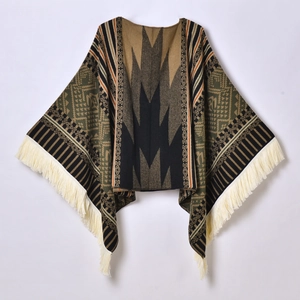 Ethnic knit poncho with geometric patterns and beige tassels on a white background