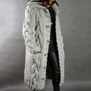Detailed macro view of the thick cable knit texture and large buttons on the grey cardigan