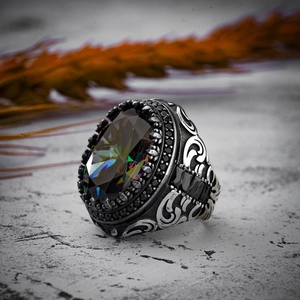 Macro detail of men's vintage copper ring with iridescent gemstone and black accents