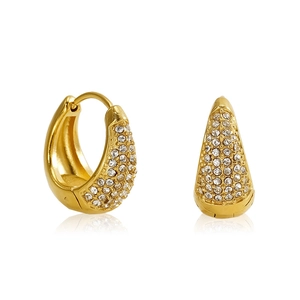 Détail de boucles d'oreilles créoles dorées avec pavé de pierres et fermoir à charnière