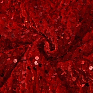 Détail du tissu en velours à paillettes rouges montrant la texture et les reflets brillants