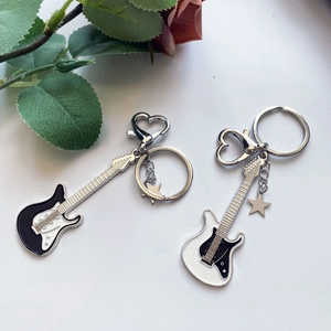 Detail of Y2K guitar keychains with heart hooks, star charms, and rose petals