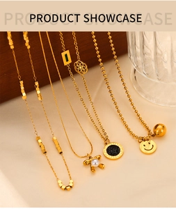 Close-up of golden necklaces with pearl bow and smiley face charms on a textured background