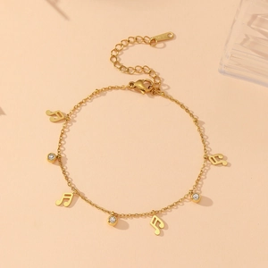 Gros plan d'un bracelet notes de musique plaqué or 18 carats avec oxydes de zirconium