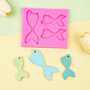 Pink silicone mold for DIY fish tail resin pendants with finished examples