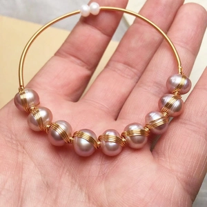 Detail of lavender freshwater pearls and gold wire-wrapped handmade bangle bracelet