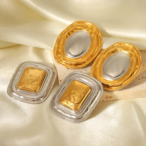 Detail of two-tone geometric oval and rectangular stainless steel hoop earrings