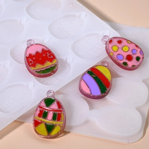 Detail of Easter egg resin molds showing textured patterns and finished pendant charms