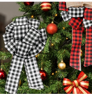 Close-up of rustic plaid burlap bows on a decorated Christmas tree with festive warm lights